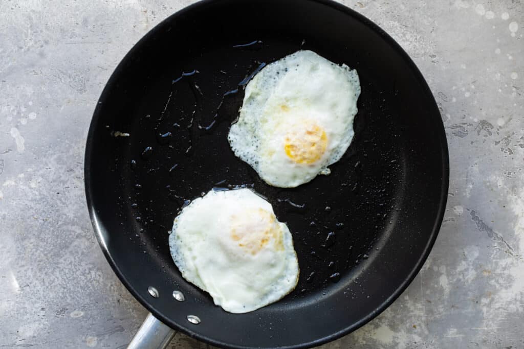 Dos huevos estrellados con la yema cocida en un sartén