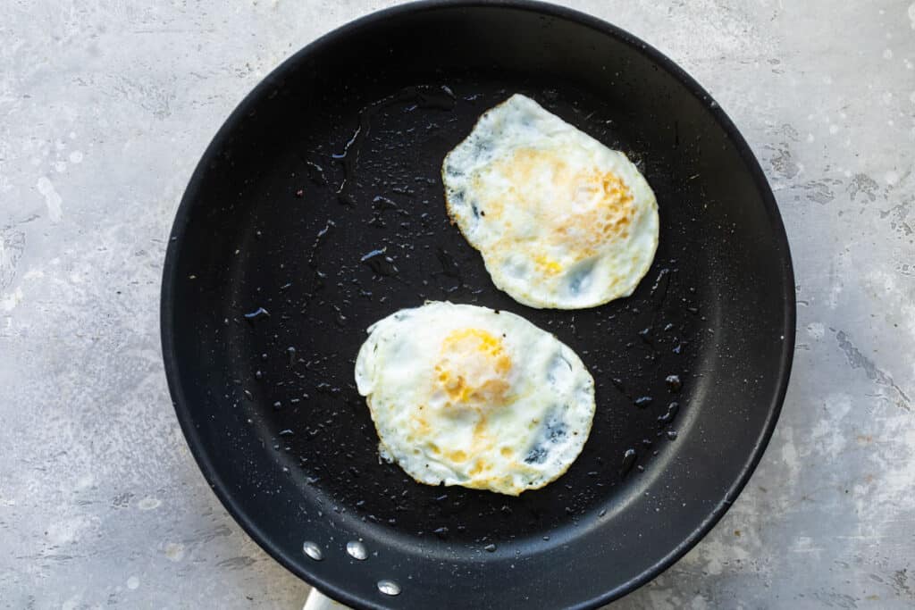 Dos huevos estrellados cocidos por ambos lados en un sartén