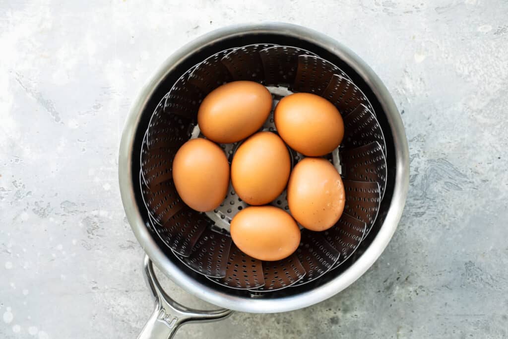 Huevos sobre una vaporera y olla metálicas