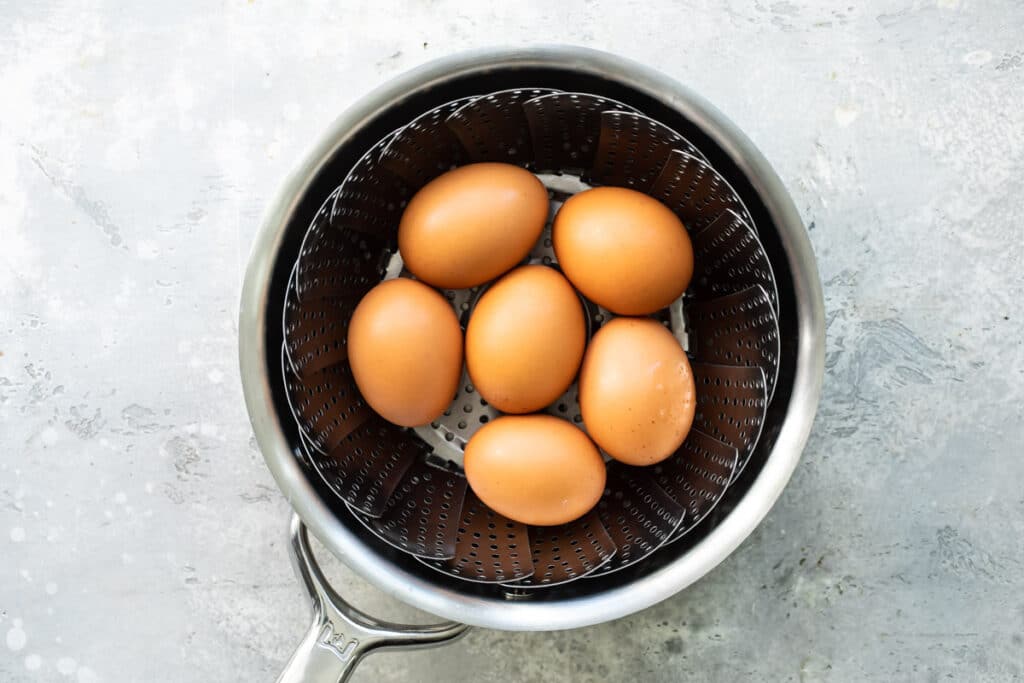 Huevos en una canastilla vaporera dentro de una olla