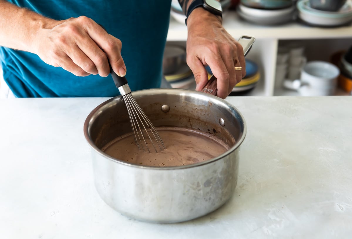 Mezclando el chocolate, ya incorporada la leche, con el batidor de globo