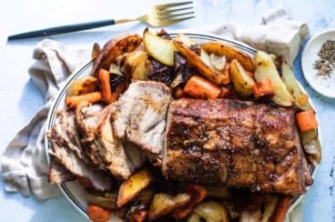 Cerdo al horno rebanado y servido con zanahorias y papas horneadas