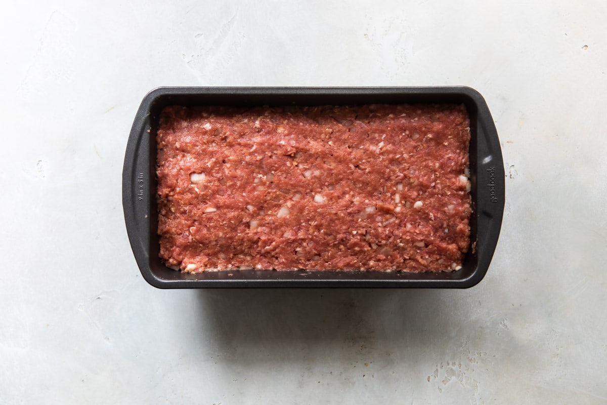 Carne molida compactada en un molde rectángulo para pan