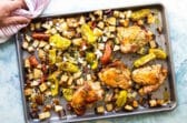 Charola recién horneada con muslos de pollo, papas, vegetales y sazón mediterráneo