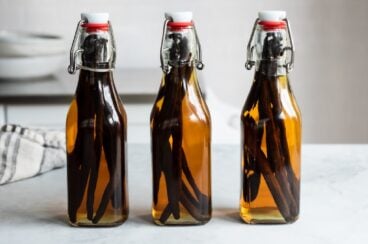 Tres botellas de vidrio con extracto de vainilla hecho en casa.
