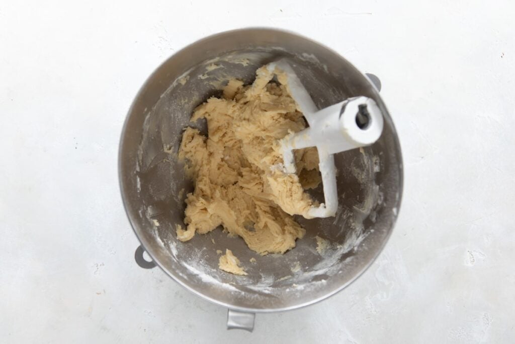 Mezclando con batidora eléctrica para hacer la pasta de base de tarta en un recipiente hondo.