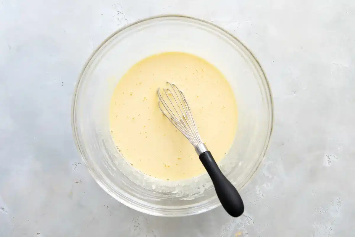 La mitad de la leche caliente se añade a la natilla para hacer la crema pastelera.