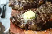 Rib eye a la parrilla servido con mantequilla con queso azul